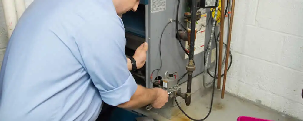 Furnace repair technician inspecting and servicing a home heating system in Houston, TX