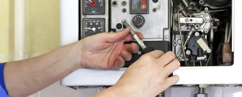 Heating repair technician adjusting boiler controls and components in Houston, TX