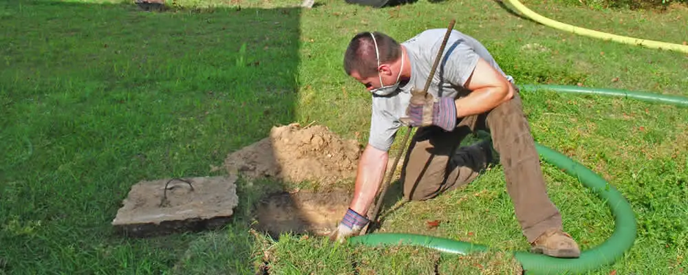 Septic pumping technician servicing a residential septic tank in Houston, TX