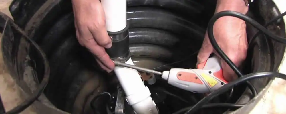 Sump pump installation technician connecting PVC discharge piping in Houston, TX