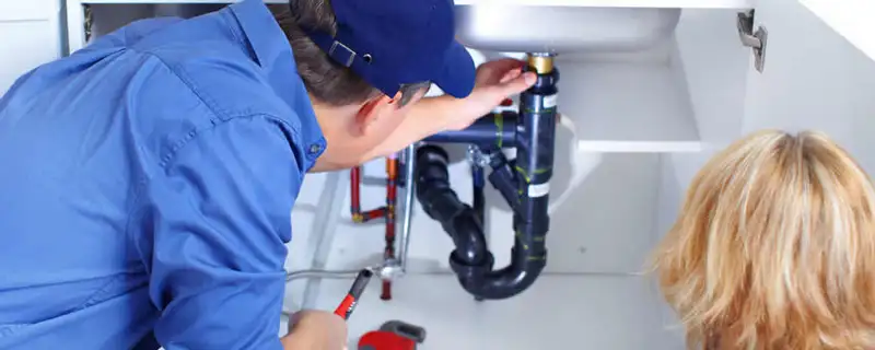 Plumber repairing under-sink drain pipes and fittings in Houston, TX